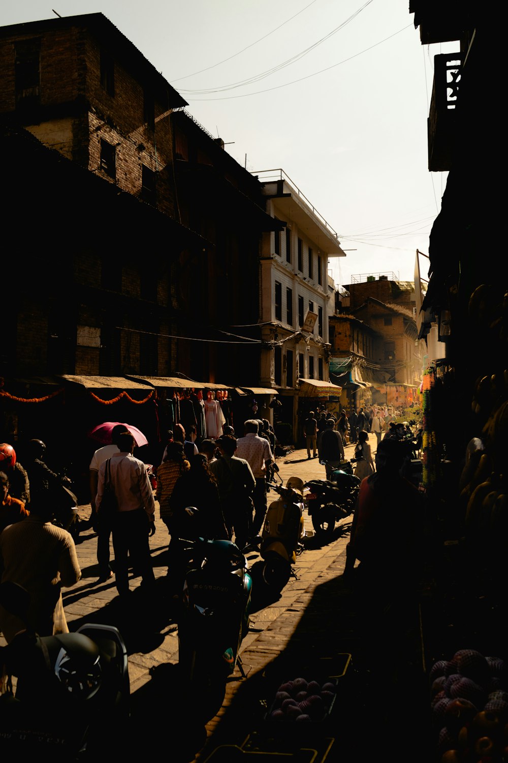 a group of people walking down a street next to buildings