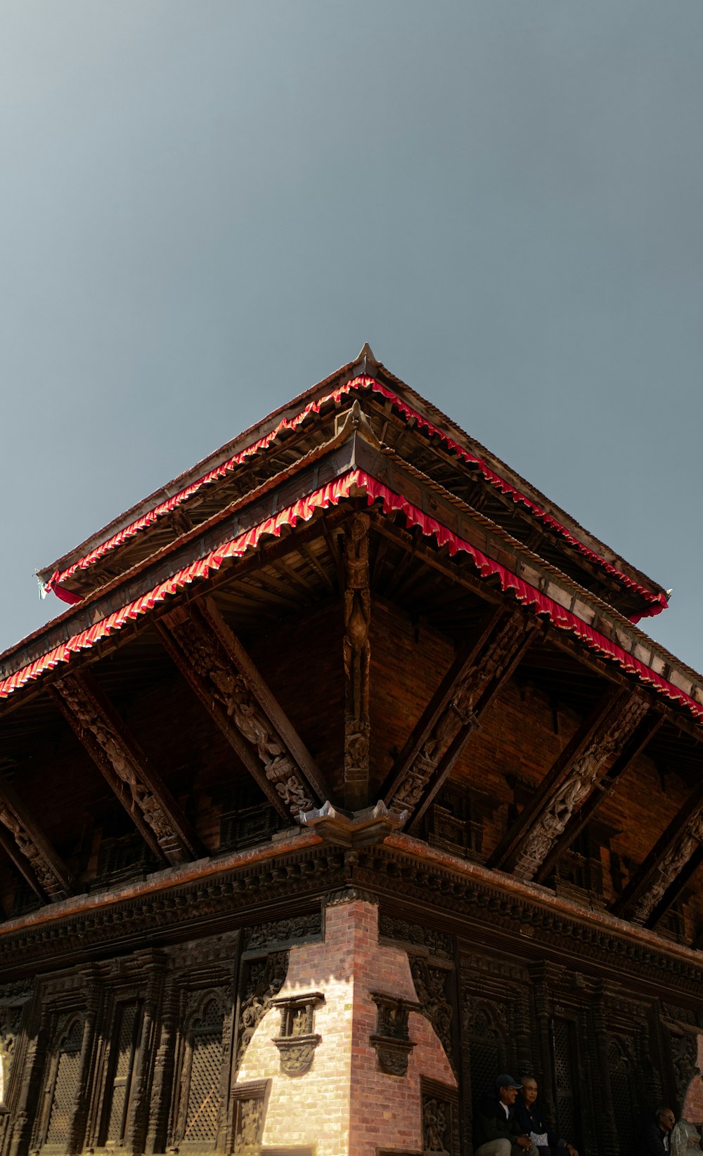 a tall wooden building with a red roof