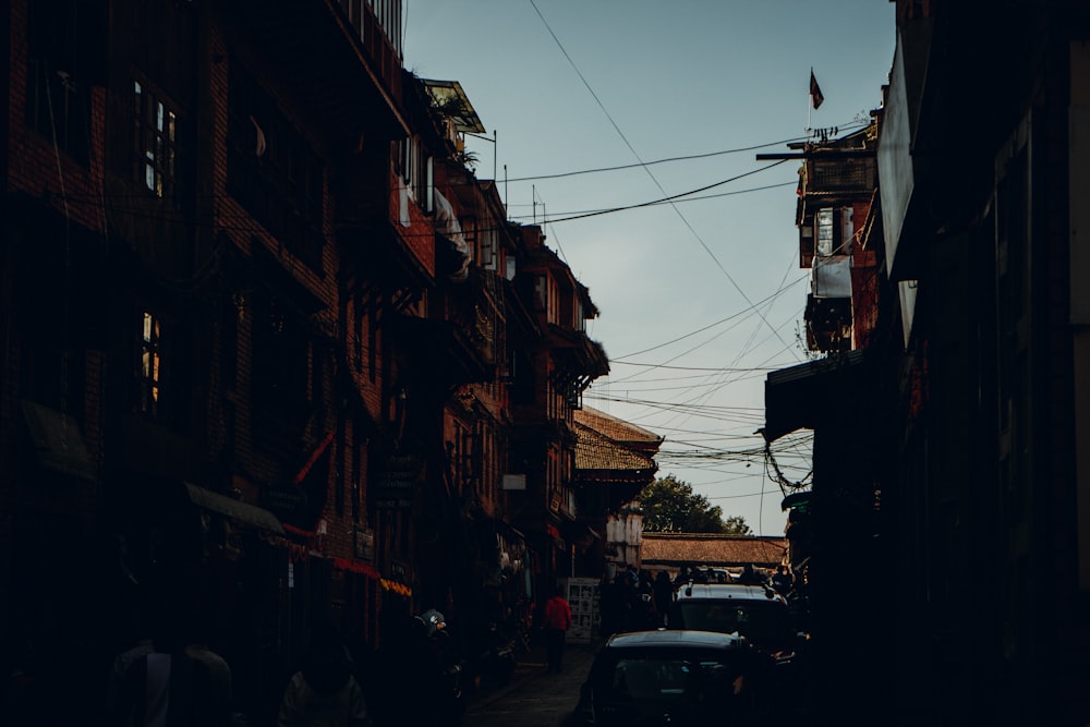 a narrow street with cars parked on both sides