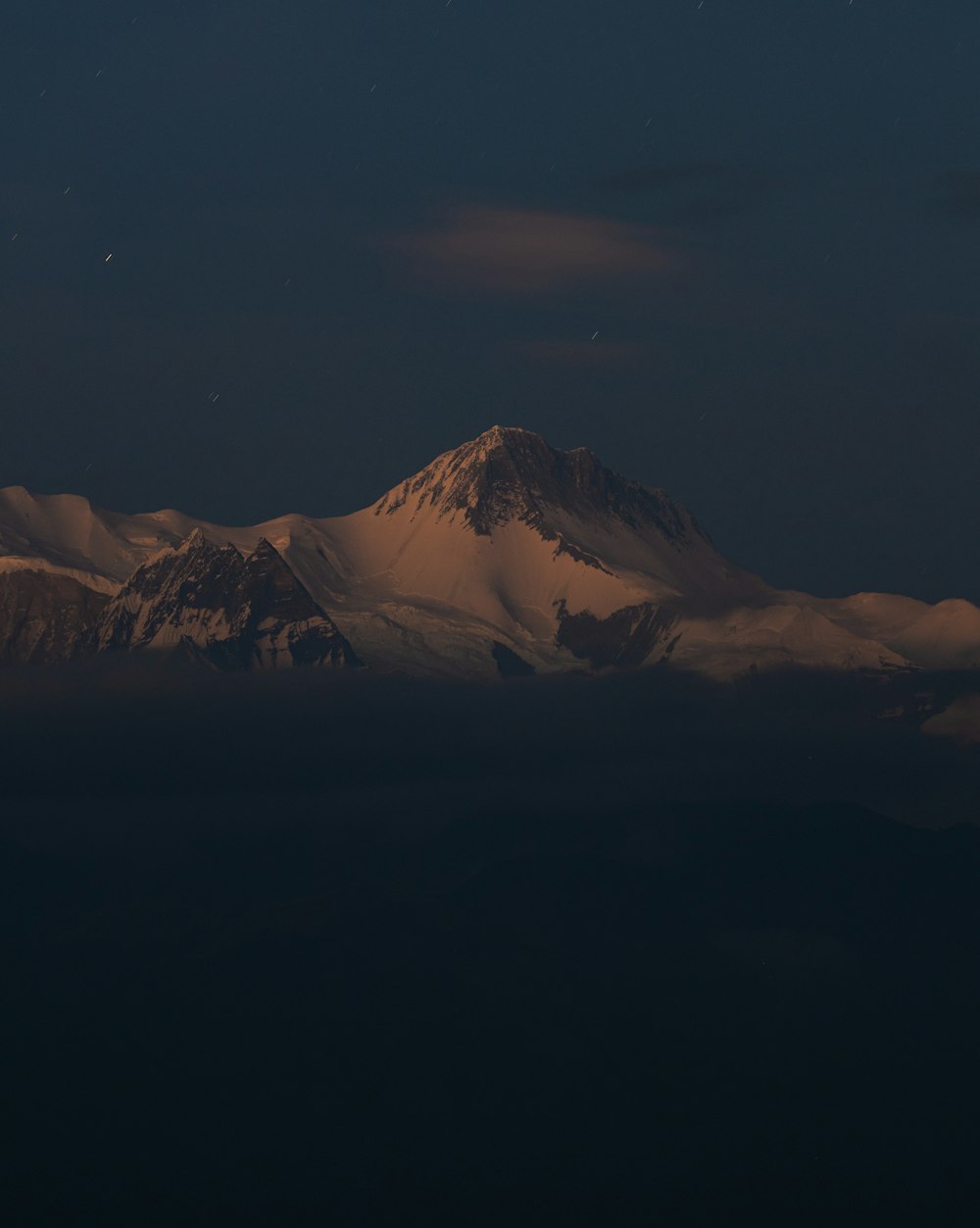 Una vista de una montaña cubierta de nieve por la noche