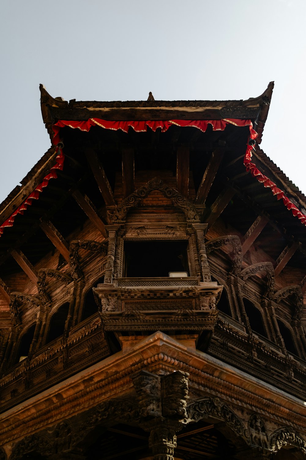 a tall wooden building with a clock on it's side