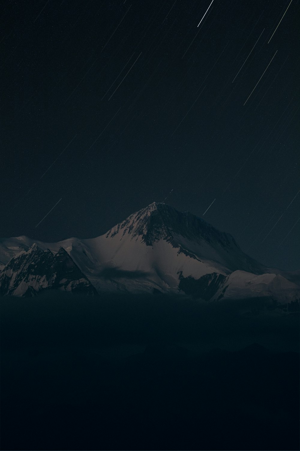 a snow covered mountain under a night sky