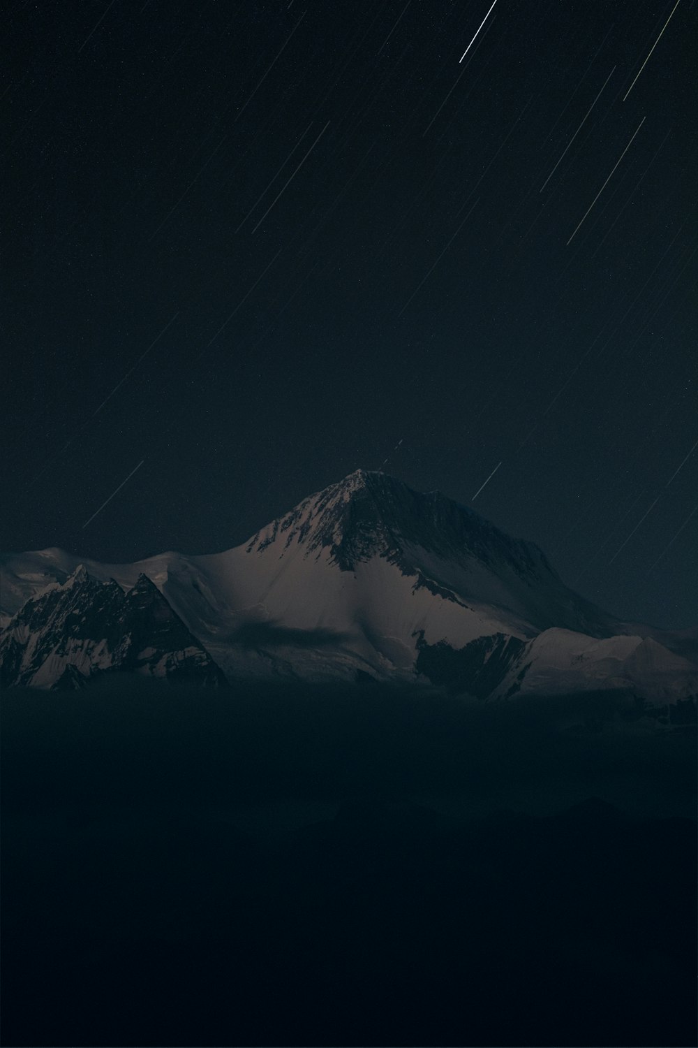 una montaña cubierta de nieve bajo un cielo nocturno