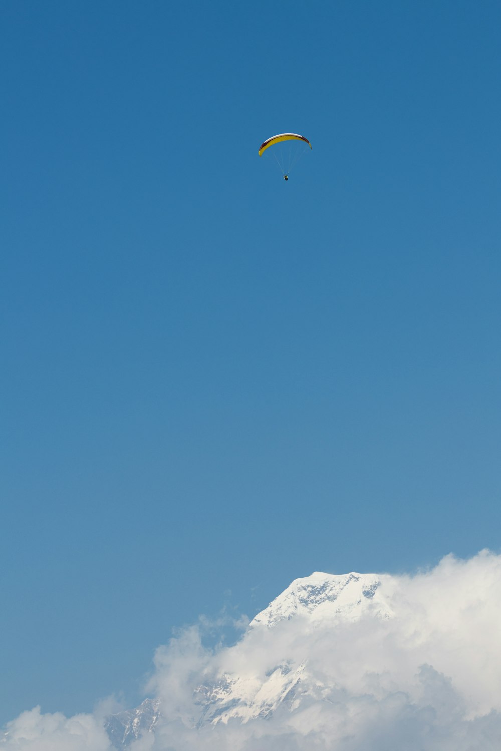 Um parapente está sobrevoando uma montanha nevada