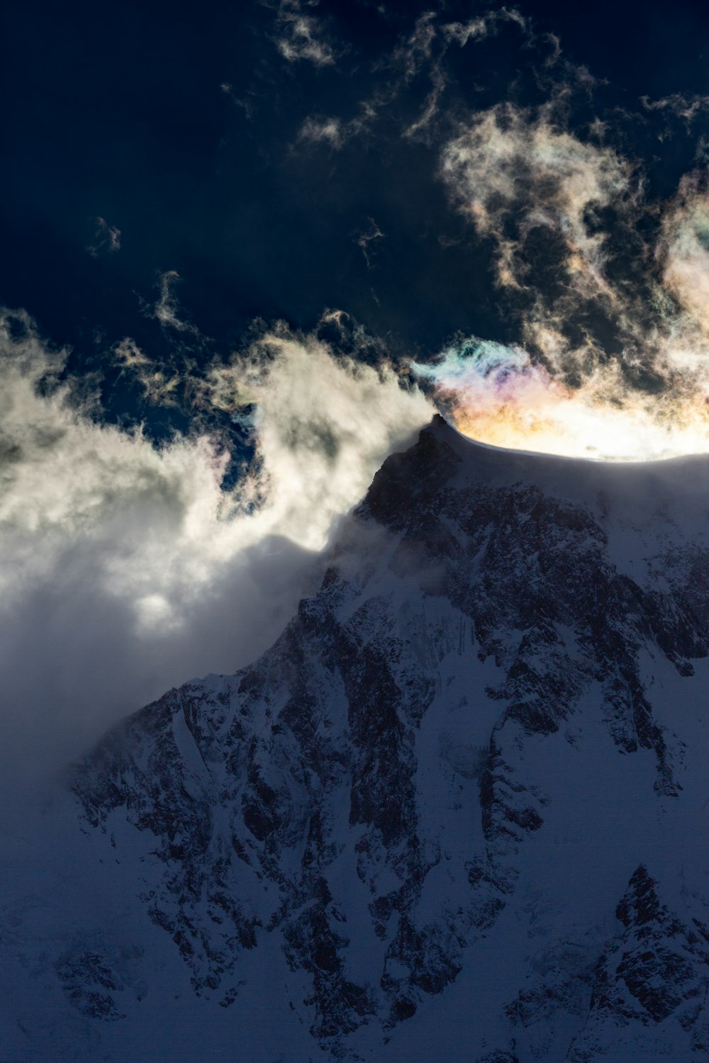 ein großer, schneebedeckter Berg unter einem bewölkten Himmel