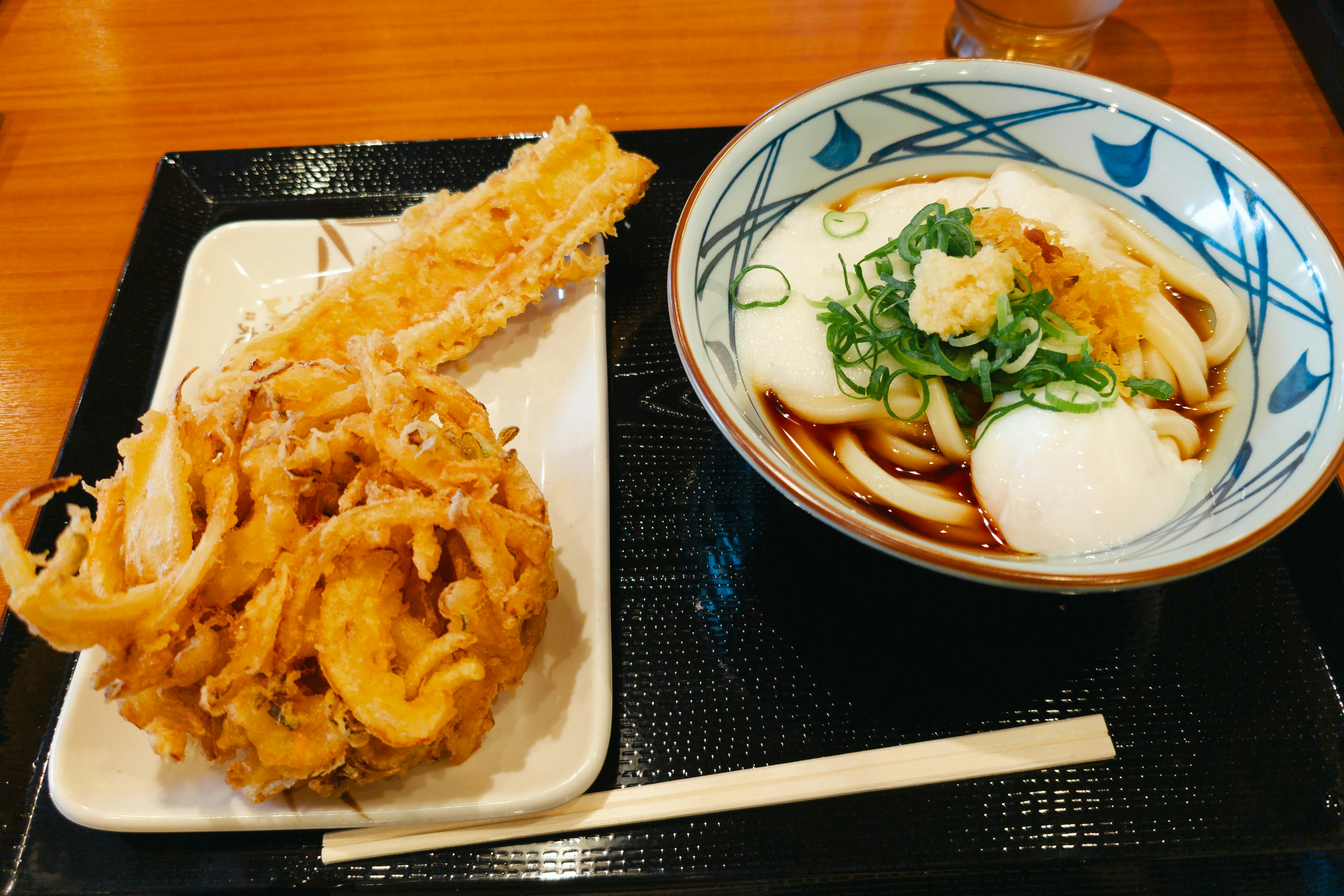 a bowl of noodles and a plate of food on a tray