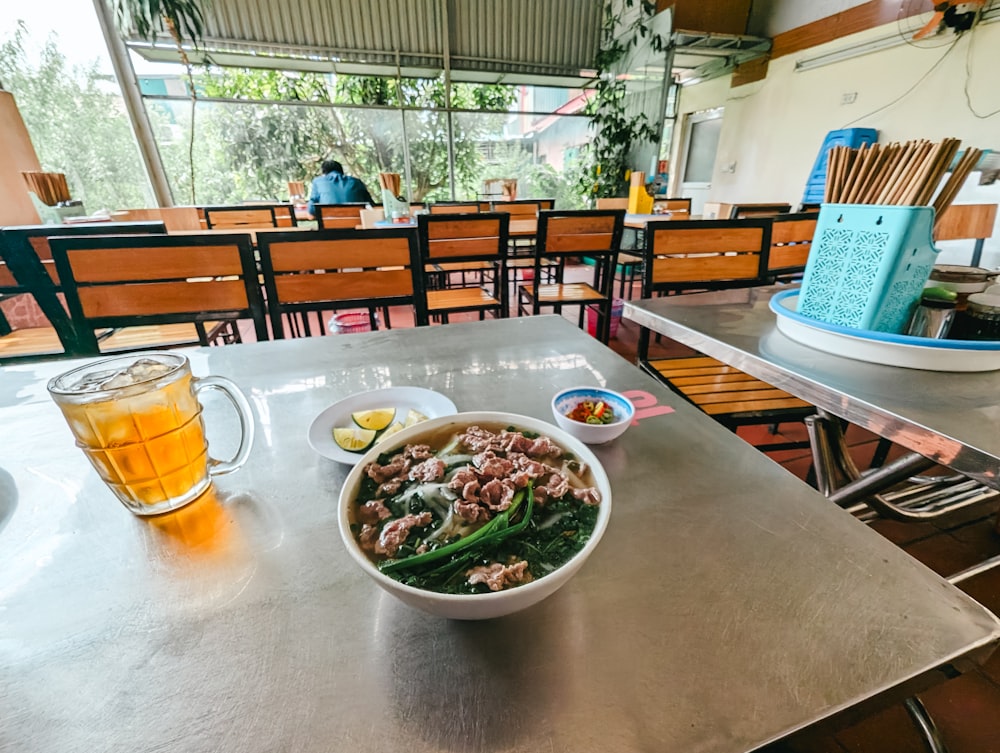 a bowl of food and a glass of beer on a table