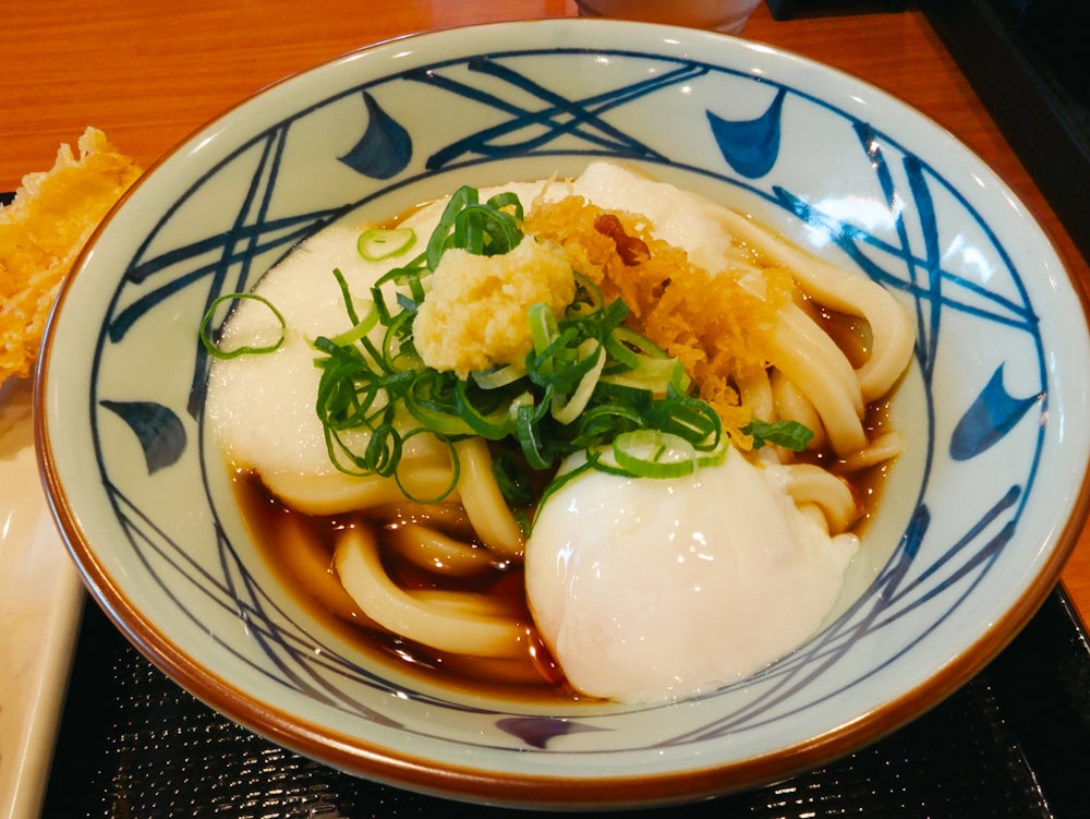a bowl of noodles with an egg on top