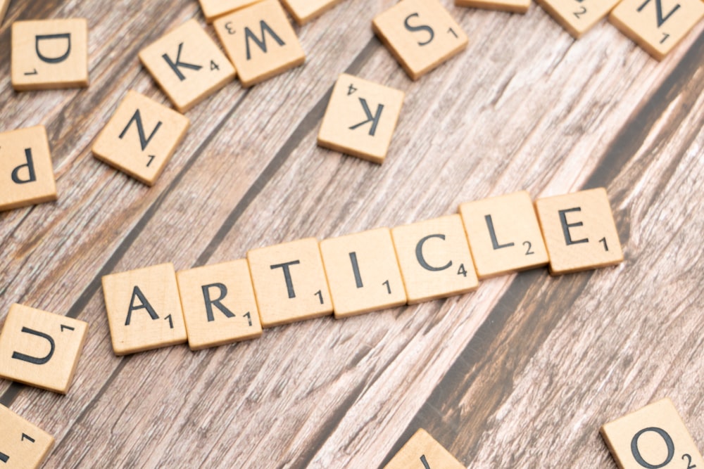 scrabble letters spelling article on a wooden surface