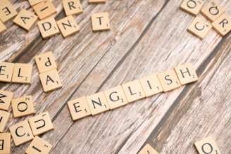 a close up of scrabble letters on a wooden surface