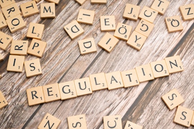 scrabble tiles spelling out the word regulation on a wooden surface
