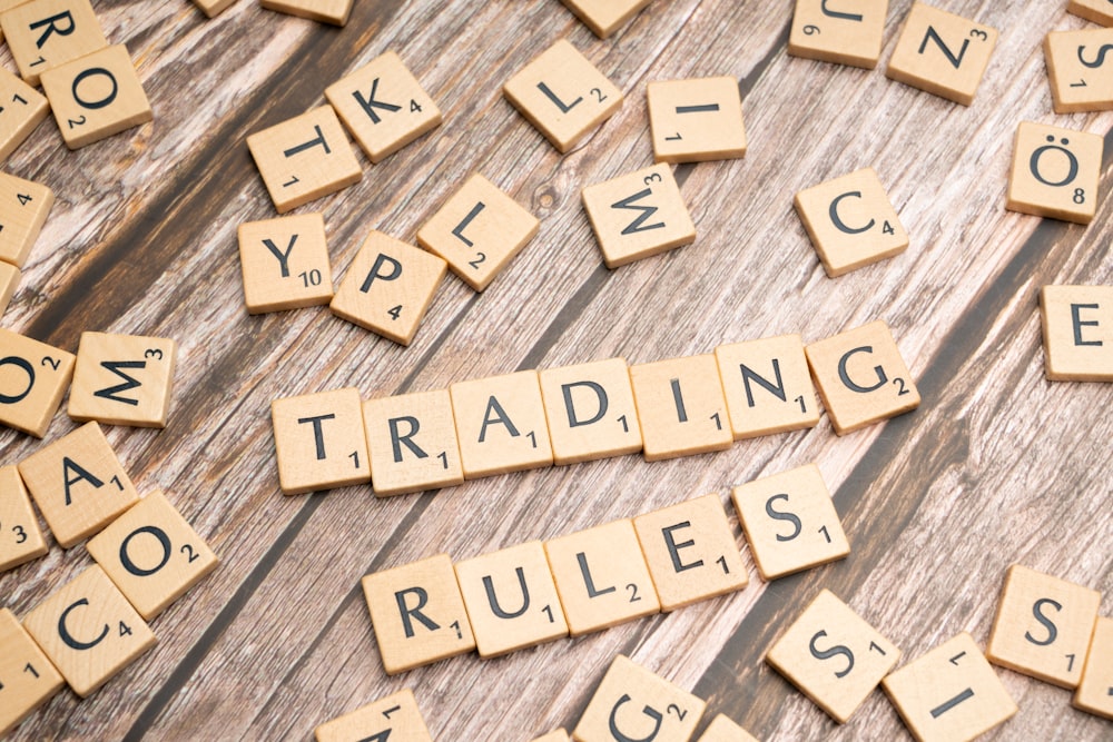 scrabble tiles spelling trading rules on a wooden table