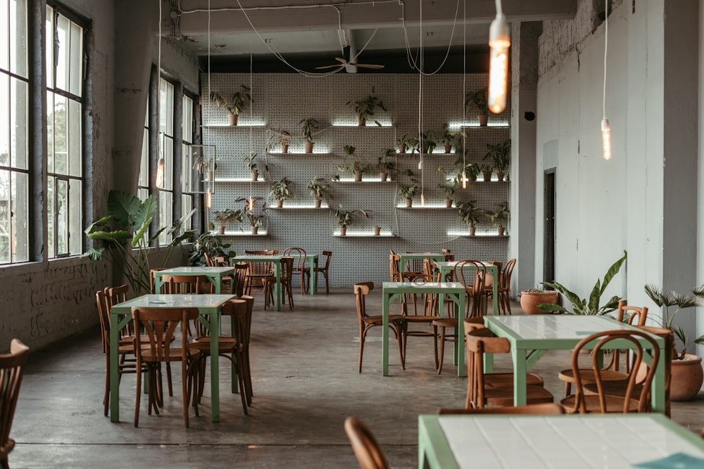 ein Restaurant mit Tischen und Stühlen und Pflanzen an der Wand
