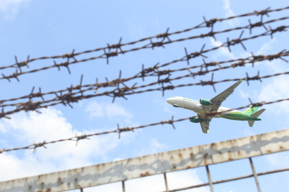 a plane flying over a barbed wire fence