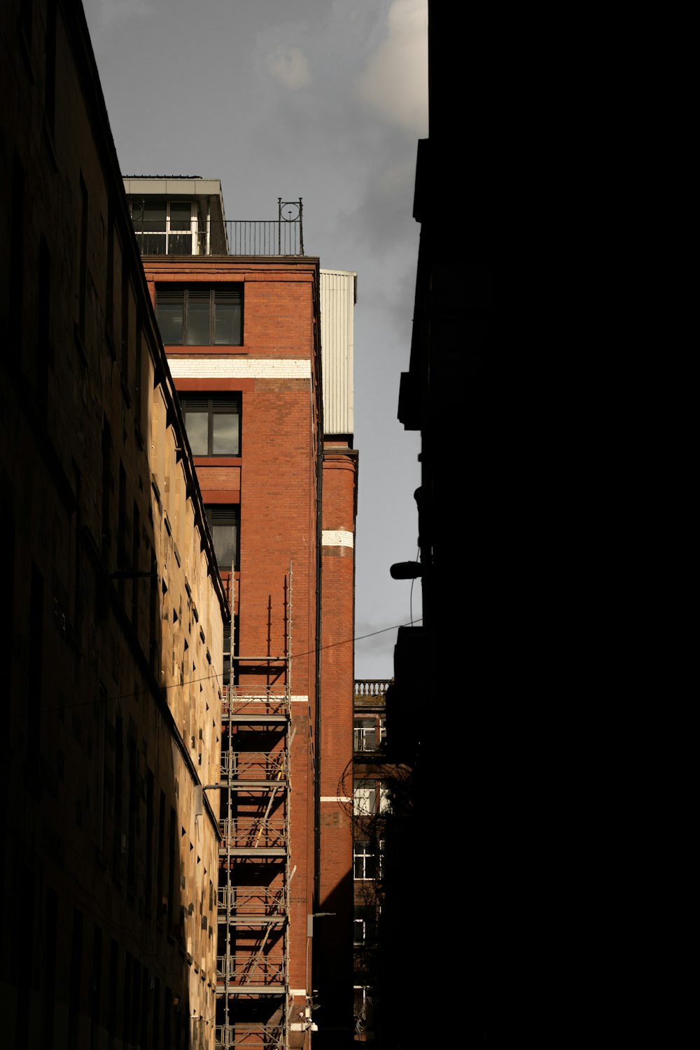 a tall brick building with a fire escape on top of it