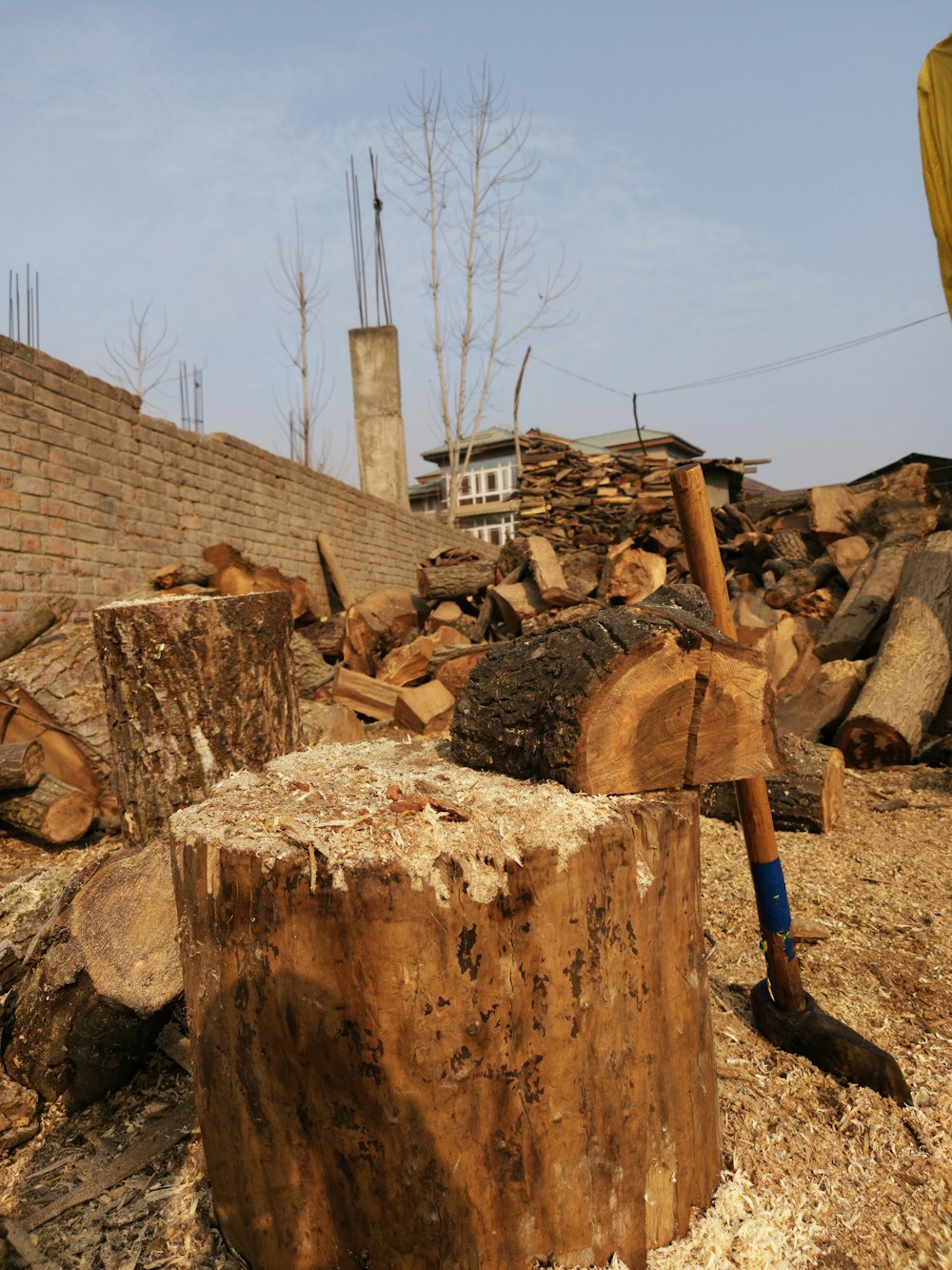 a pile of wood sitting next to a brick wall