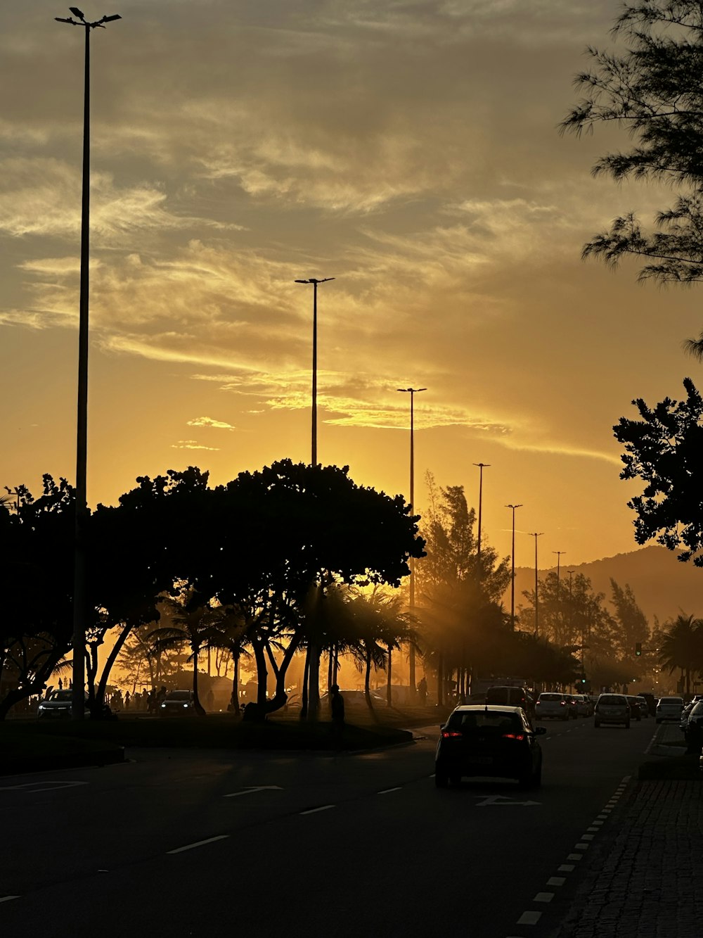 a car driving down a street at sunset