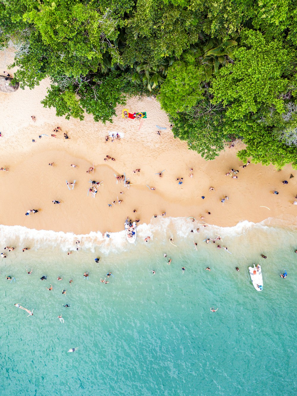 Una vista aérea de una playa con gente en el agua