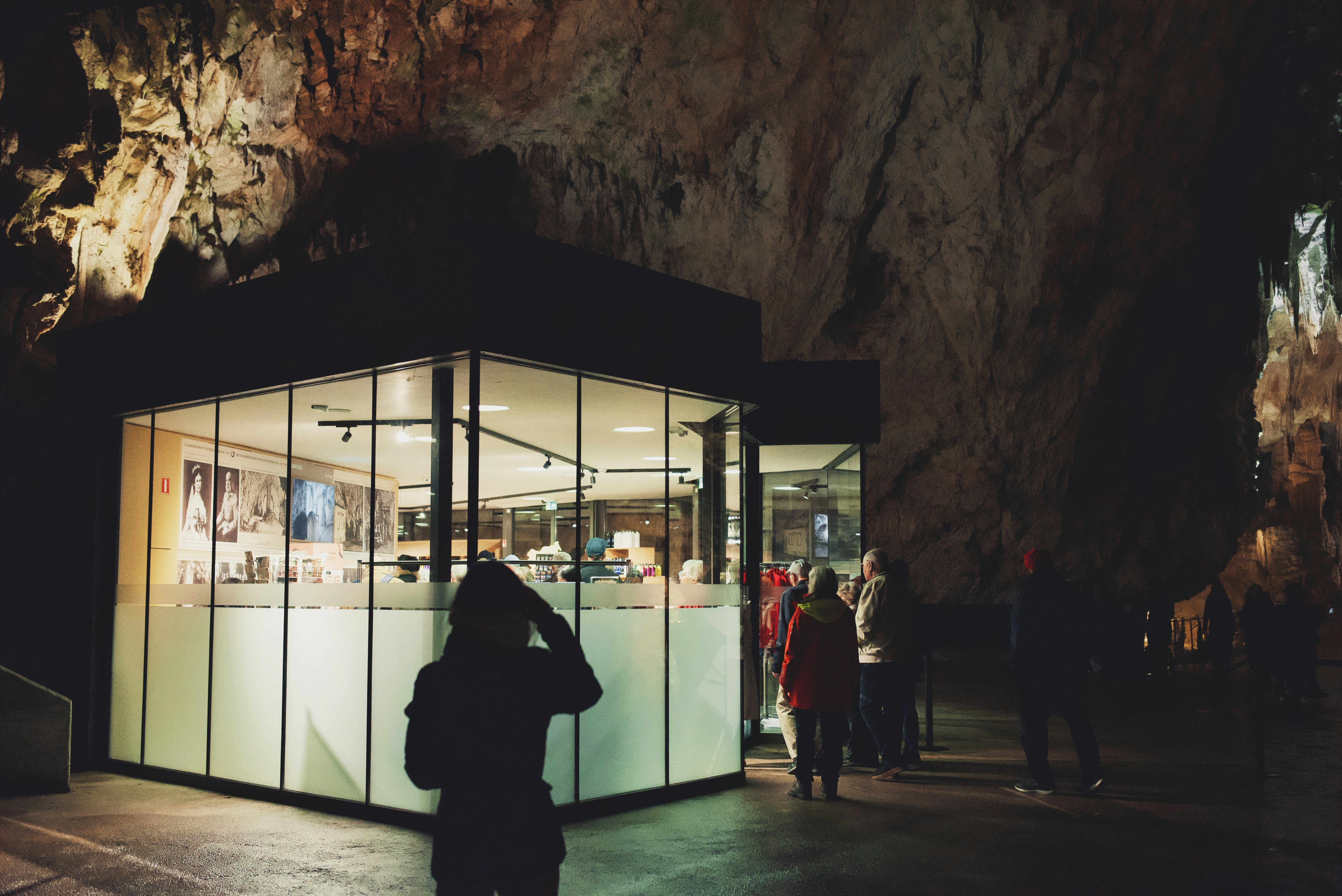 a group of people standing in front of a cave