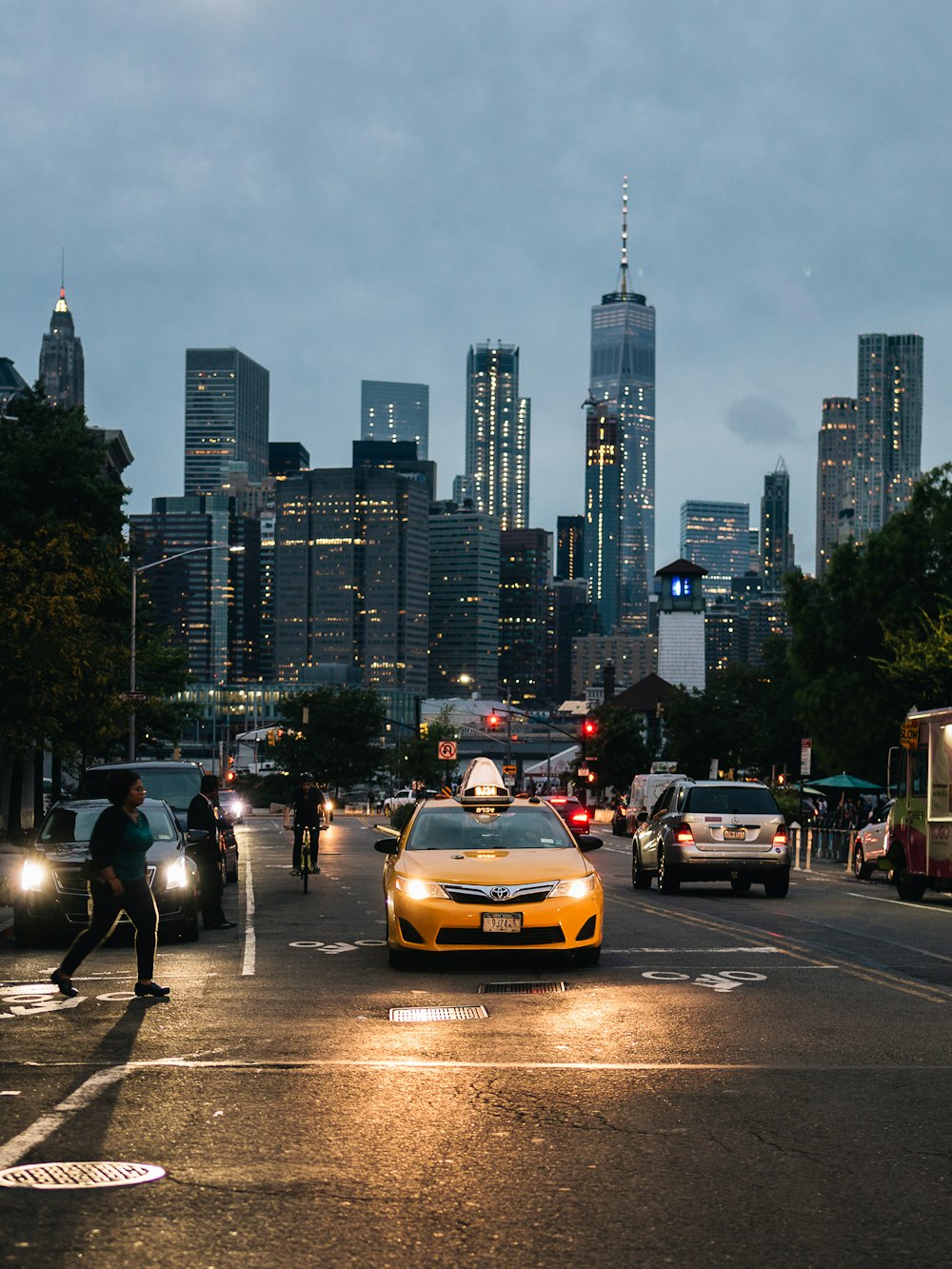a yellow taxi cab driving down a street next to tall buildings