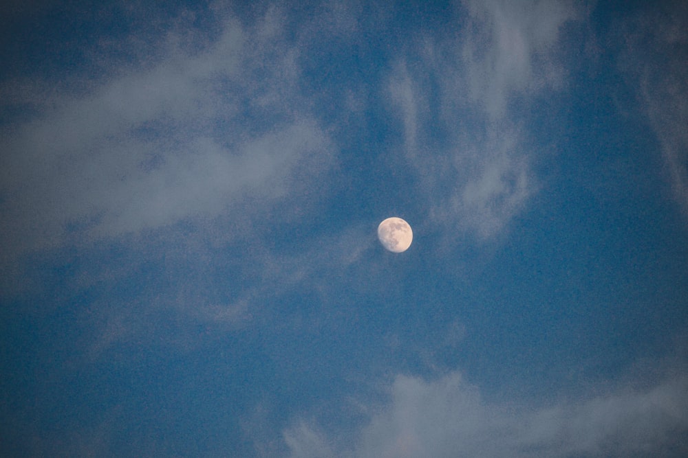 a full moon is seen through the clouds