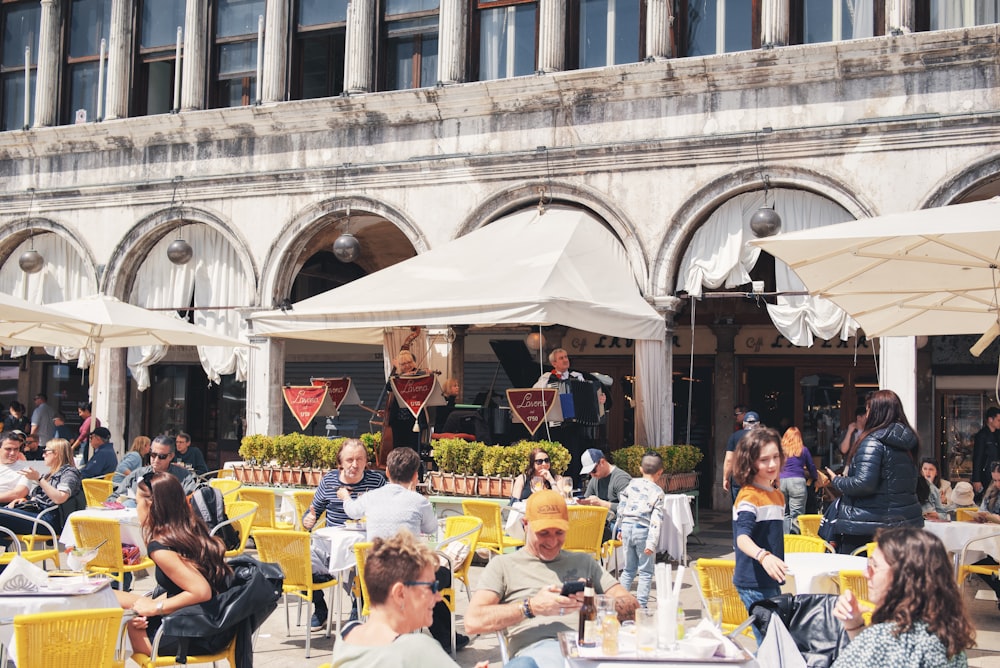 a group of people sitting at tables in front of a building