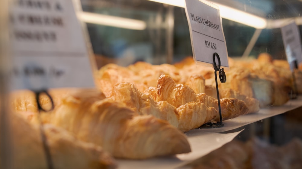 a bunch of croissants that are on a shelf