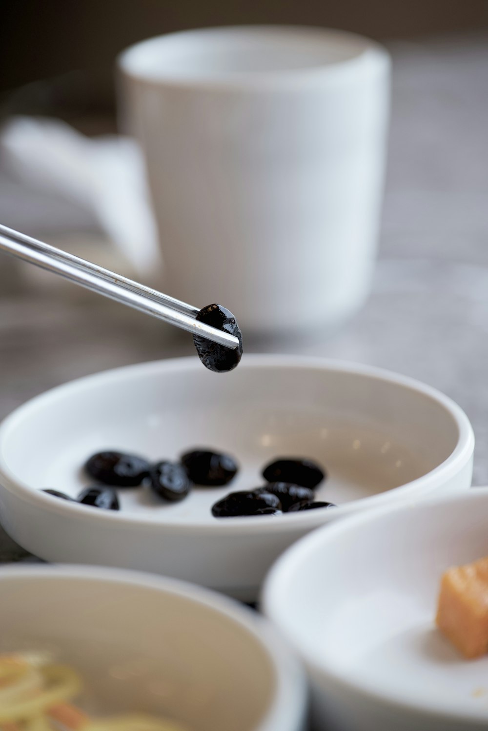 a bowl of black olives and a cup of coffee