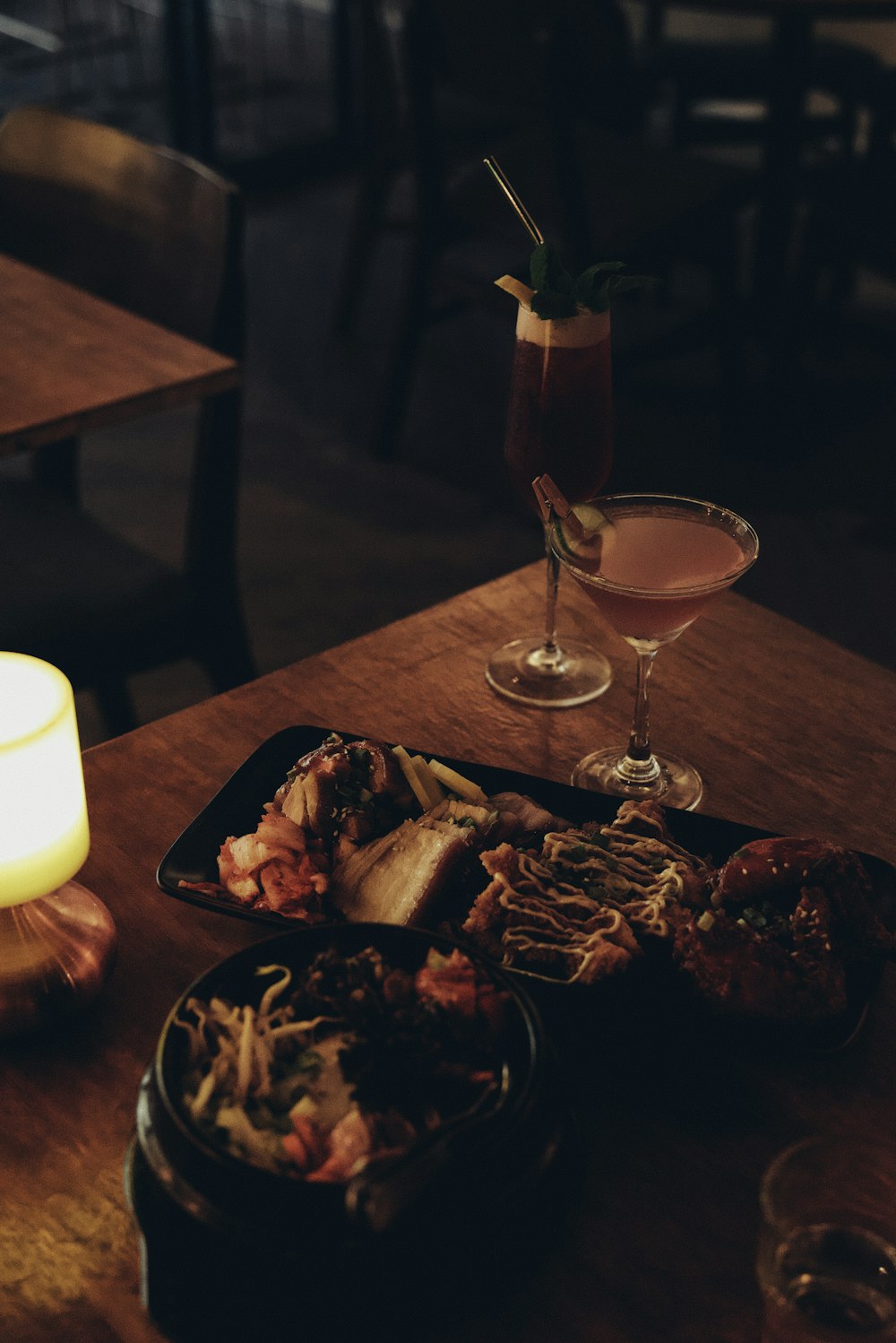 a wooden table topped with a plate of food and a drink