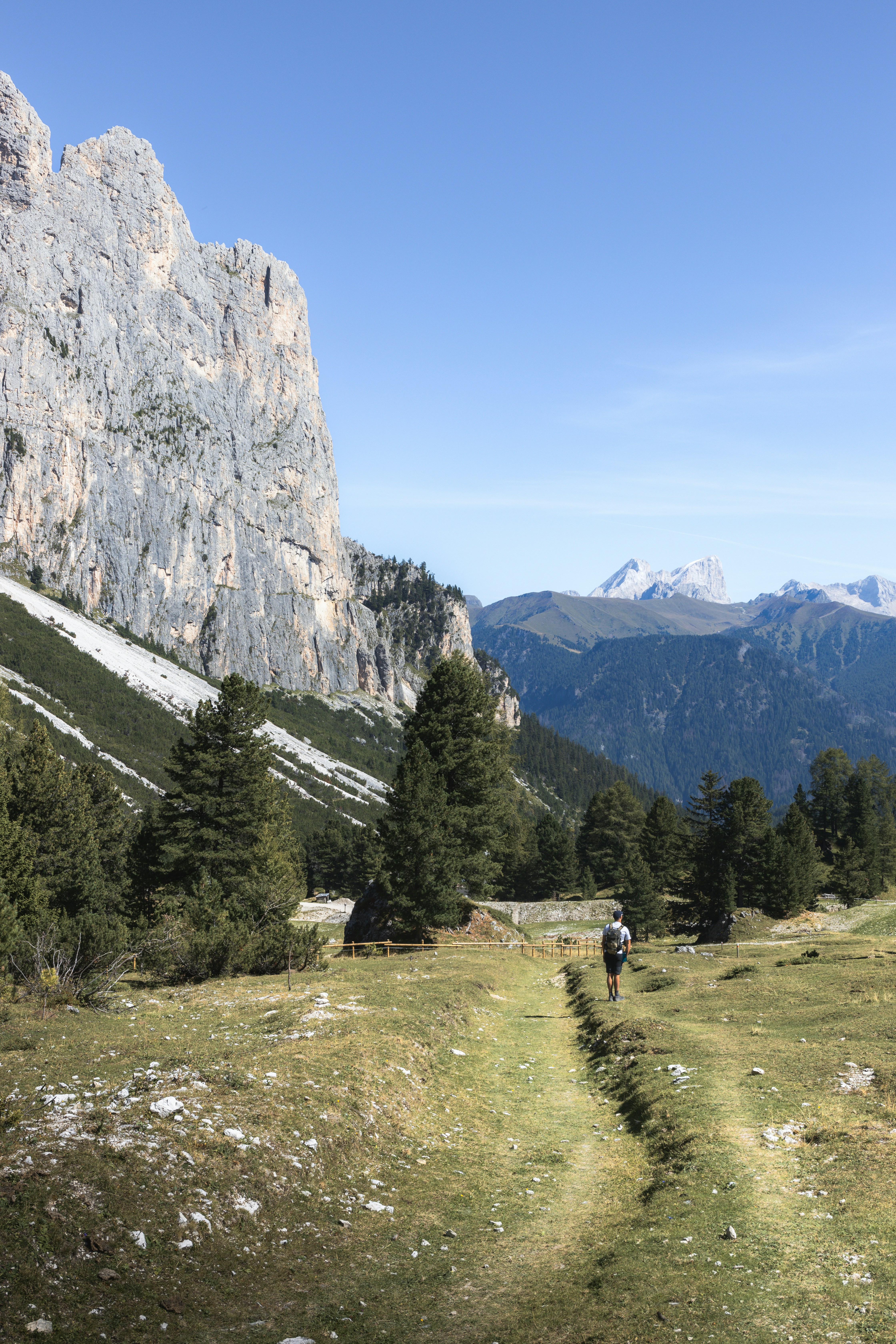 a man hiking up a trail in the mountains
