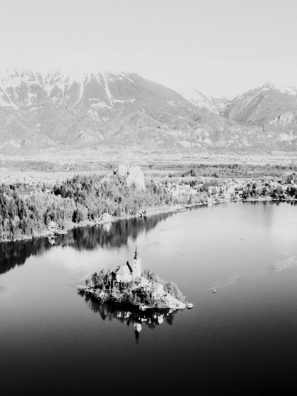 a small island in a lake surrounded by mountains