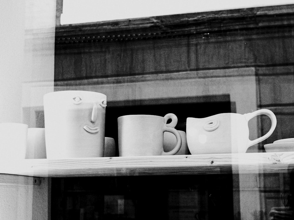 a shelf with coffee cups and mugs on it