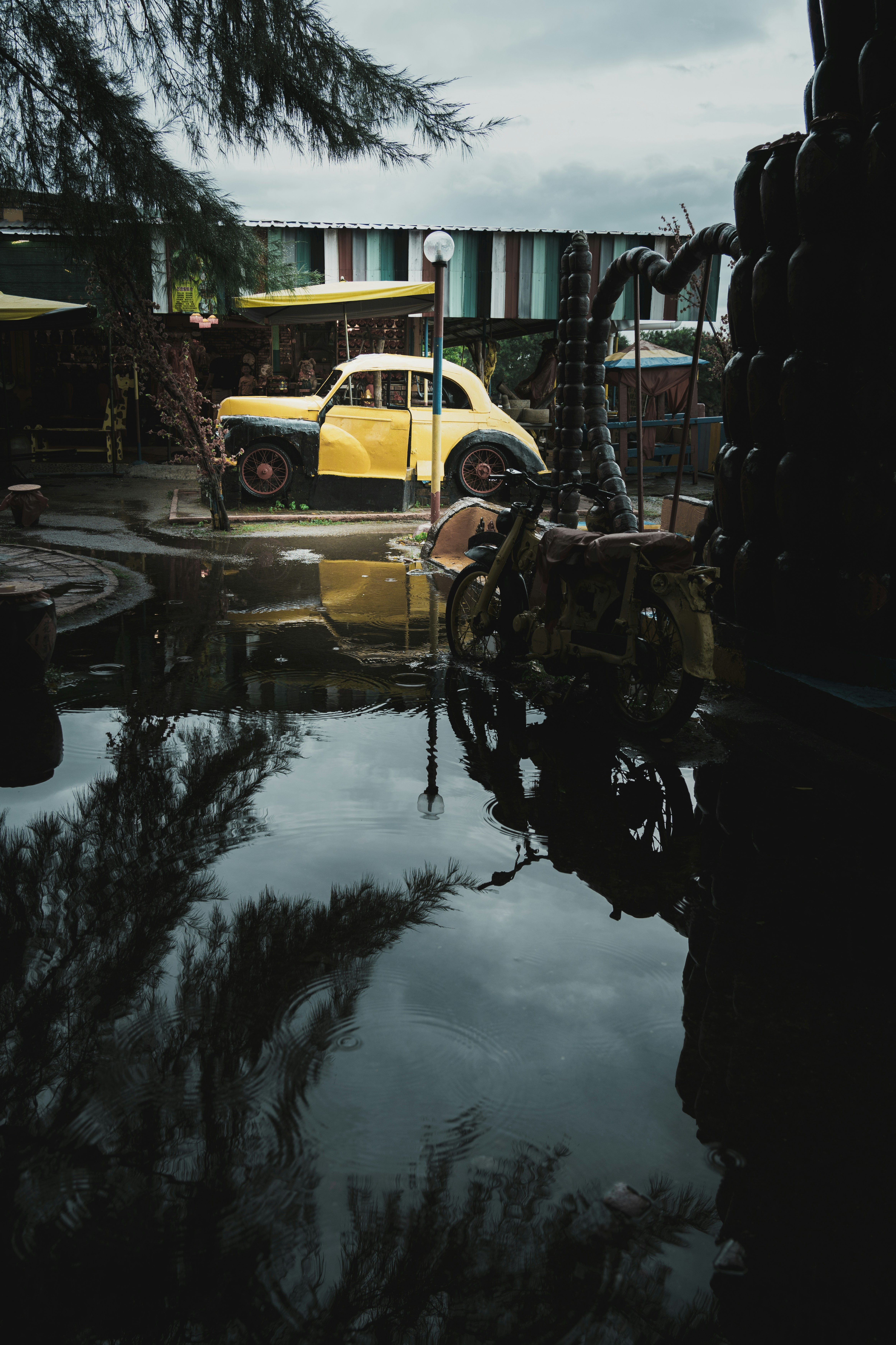 a yellow car is parked in a puddle of water