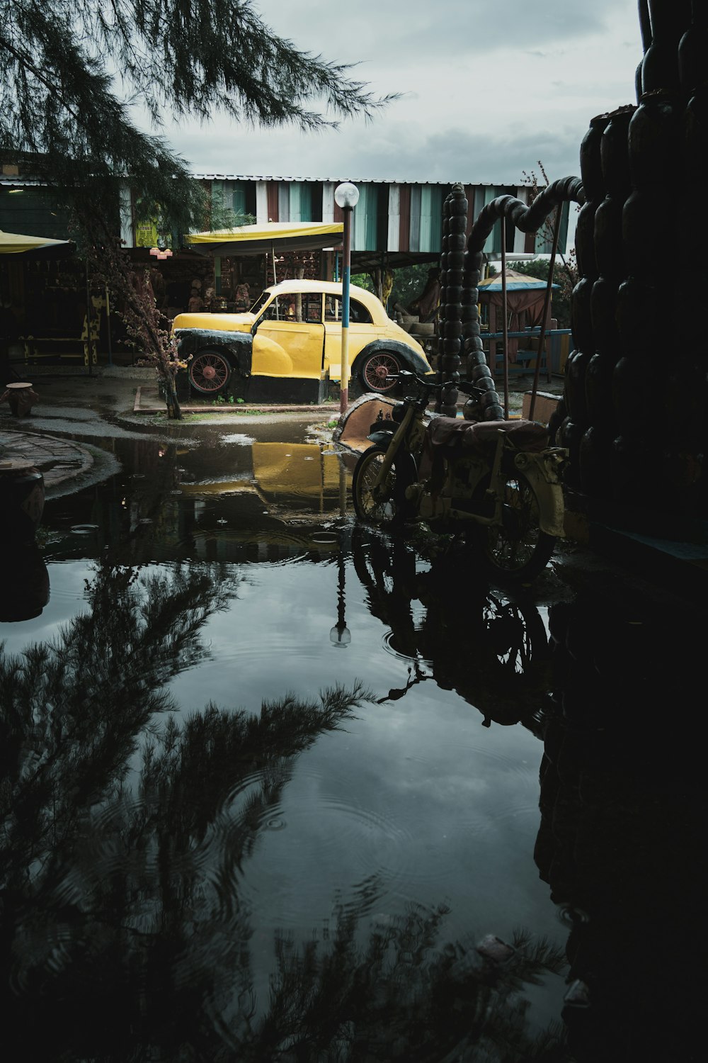 a yellow car is parked in a puddle of water
