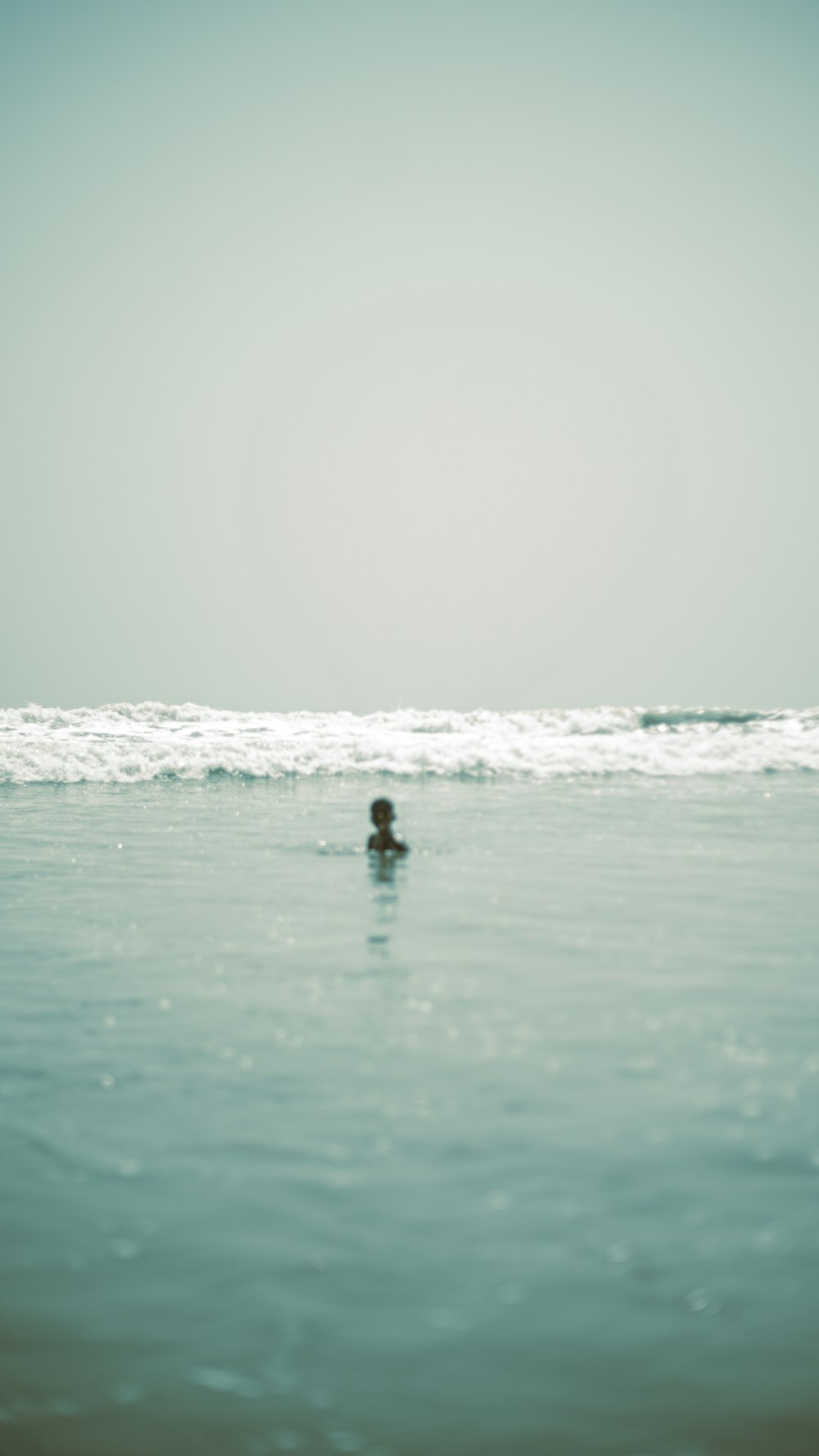 a person swimming in the ocean on a sunny day