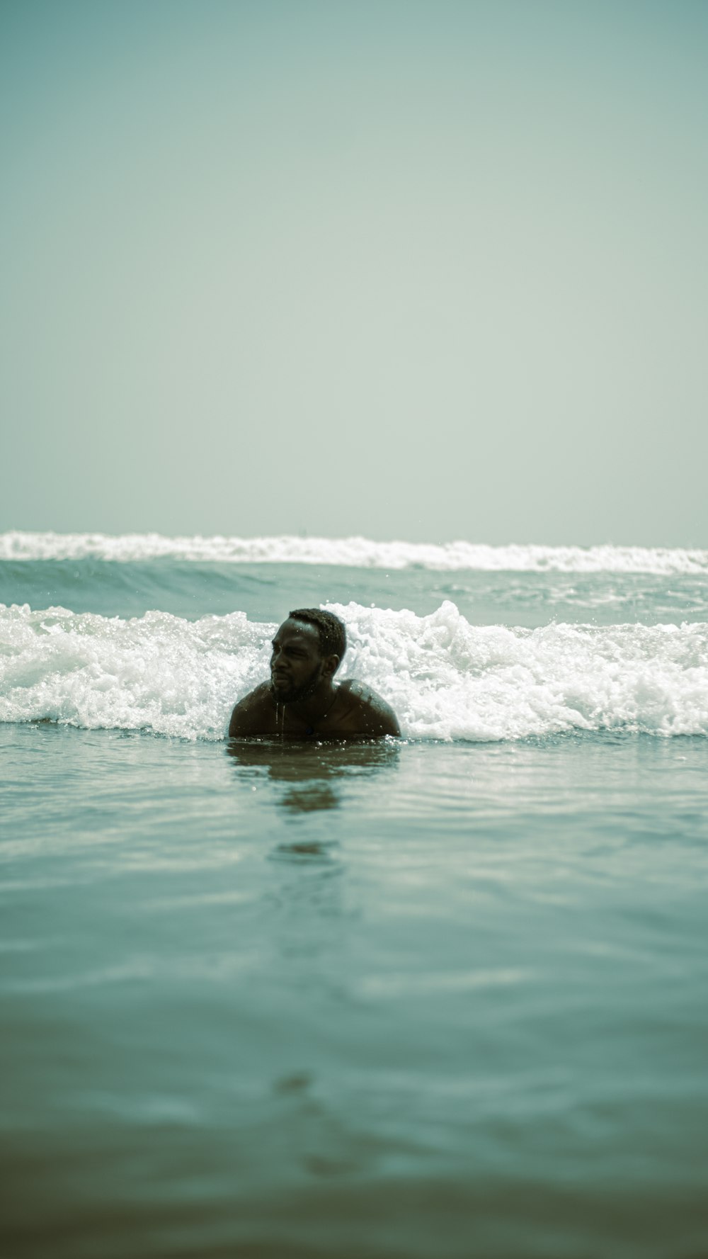 a man swimming in the ocean with his head in the water