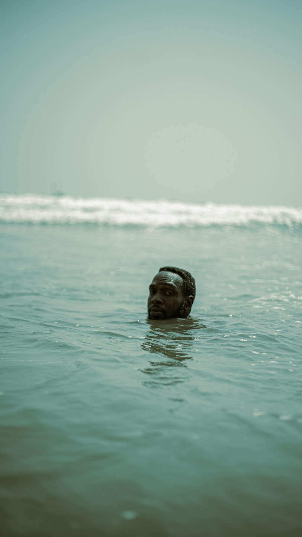 a person floating in the ocean with their head above the water