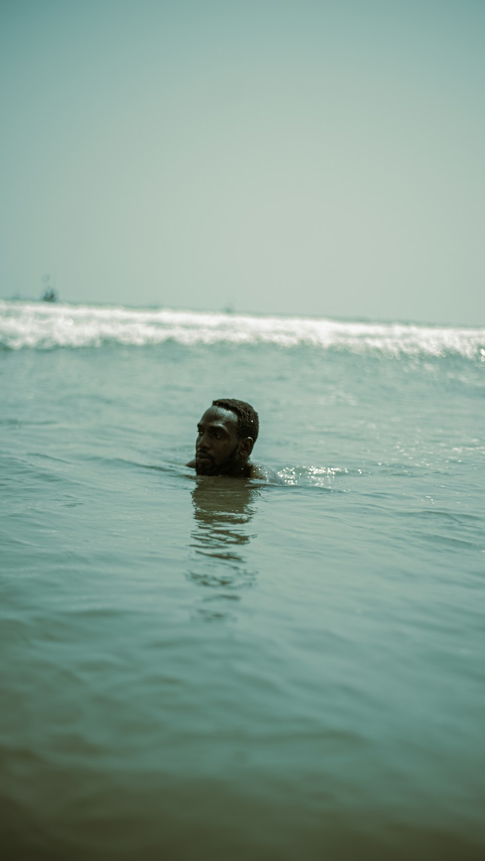 a man swimming in the ocean with his head above the water