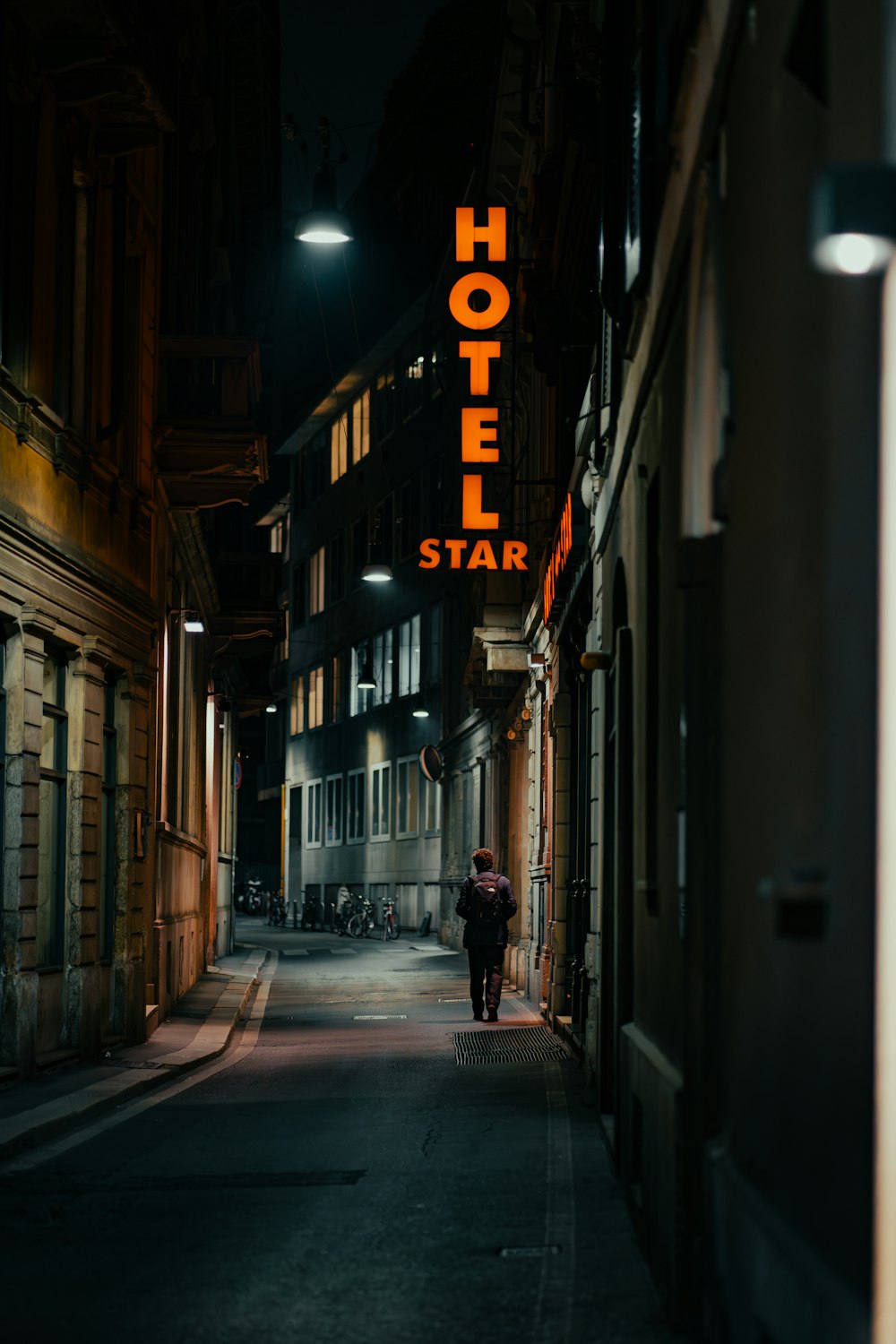 a person walking down a street at night