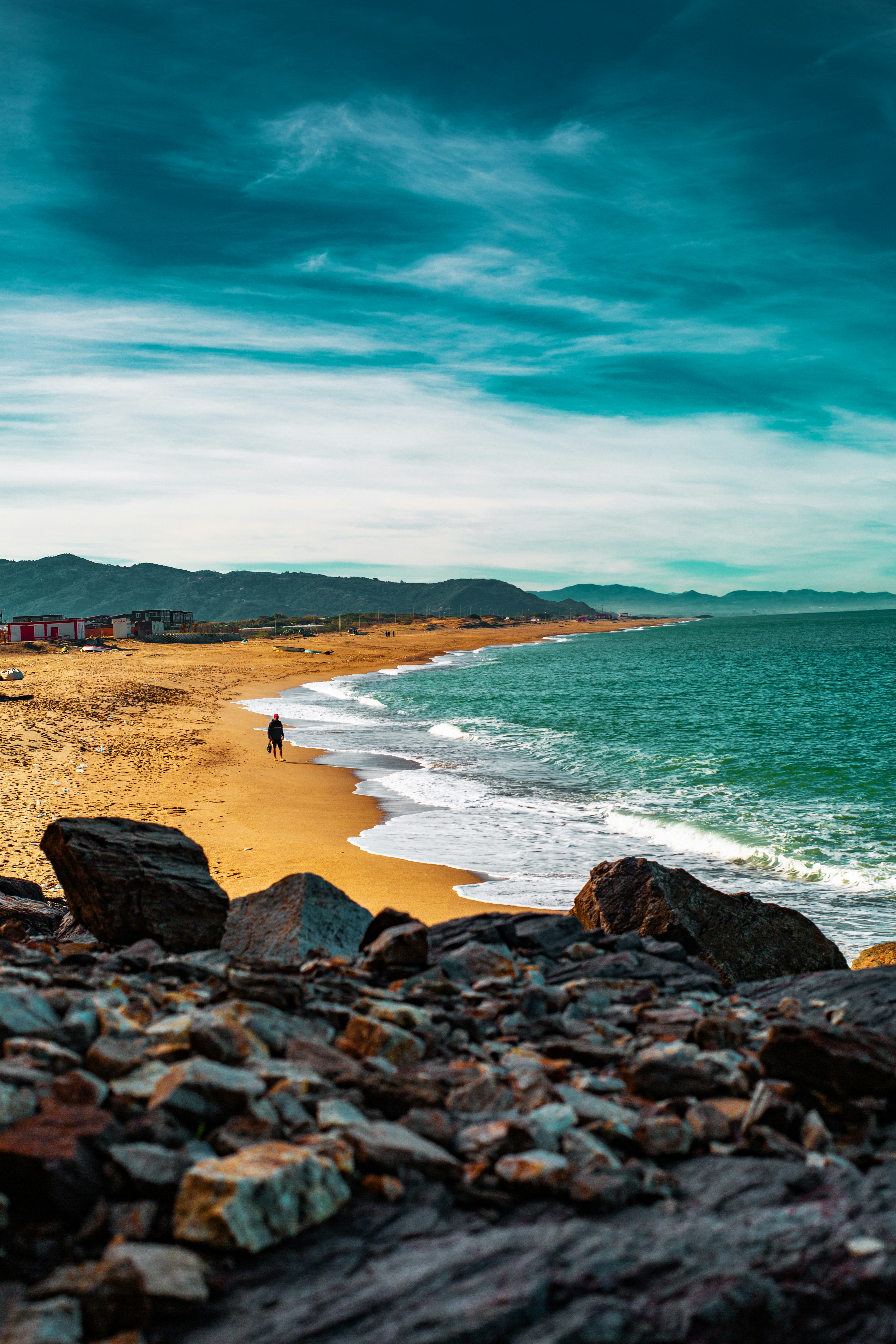 a person walking on a beach next to the ocean