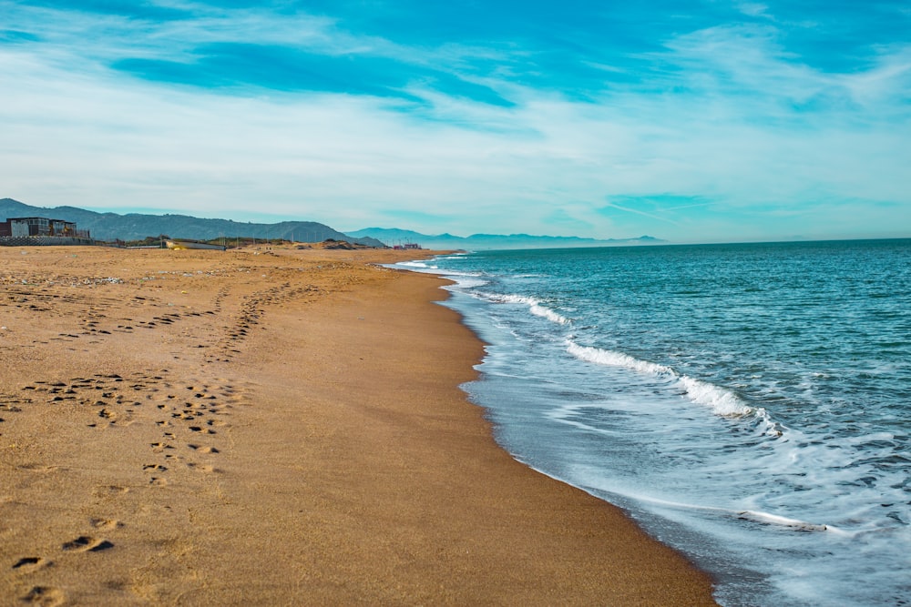 a sandy beach with footprints in the sand