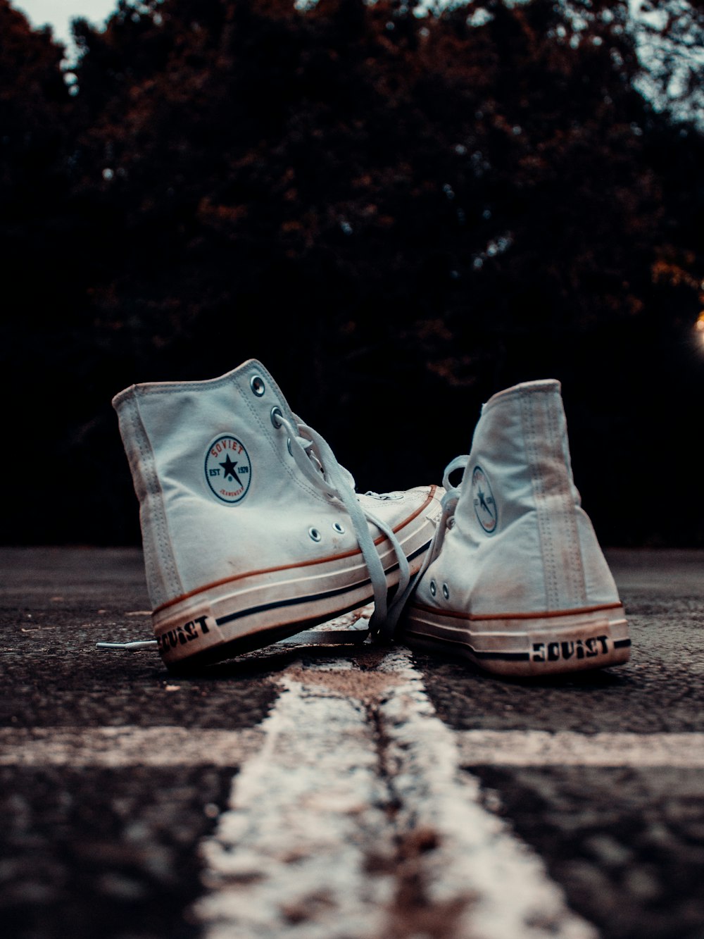 a pair of white shoes sitting on the side of a road
