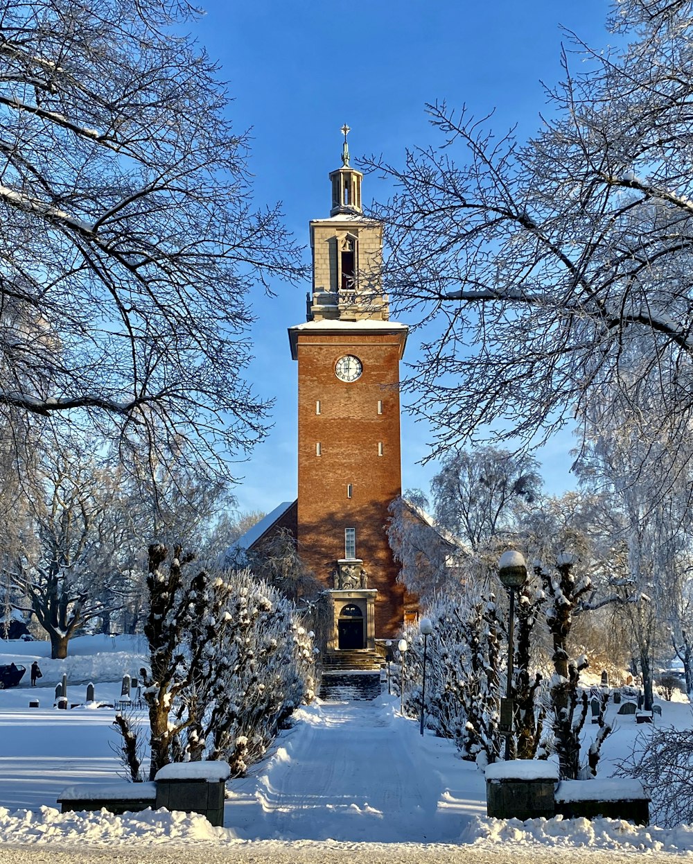 a clock tower in the middle of a snowy park
