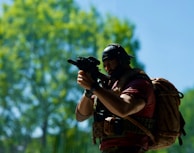 a man with a backpack holding a gun
