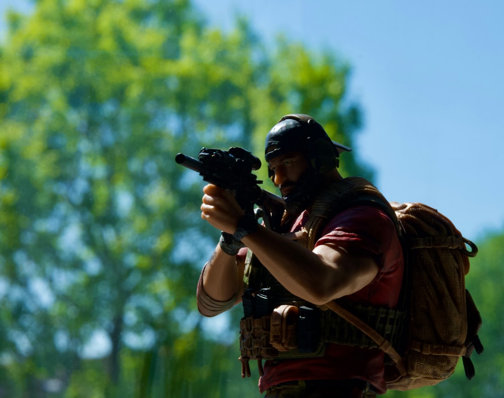 a man with a backpack holding a gun