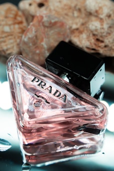 a bottle of prada next to some rocks