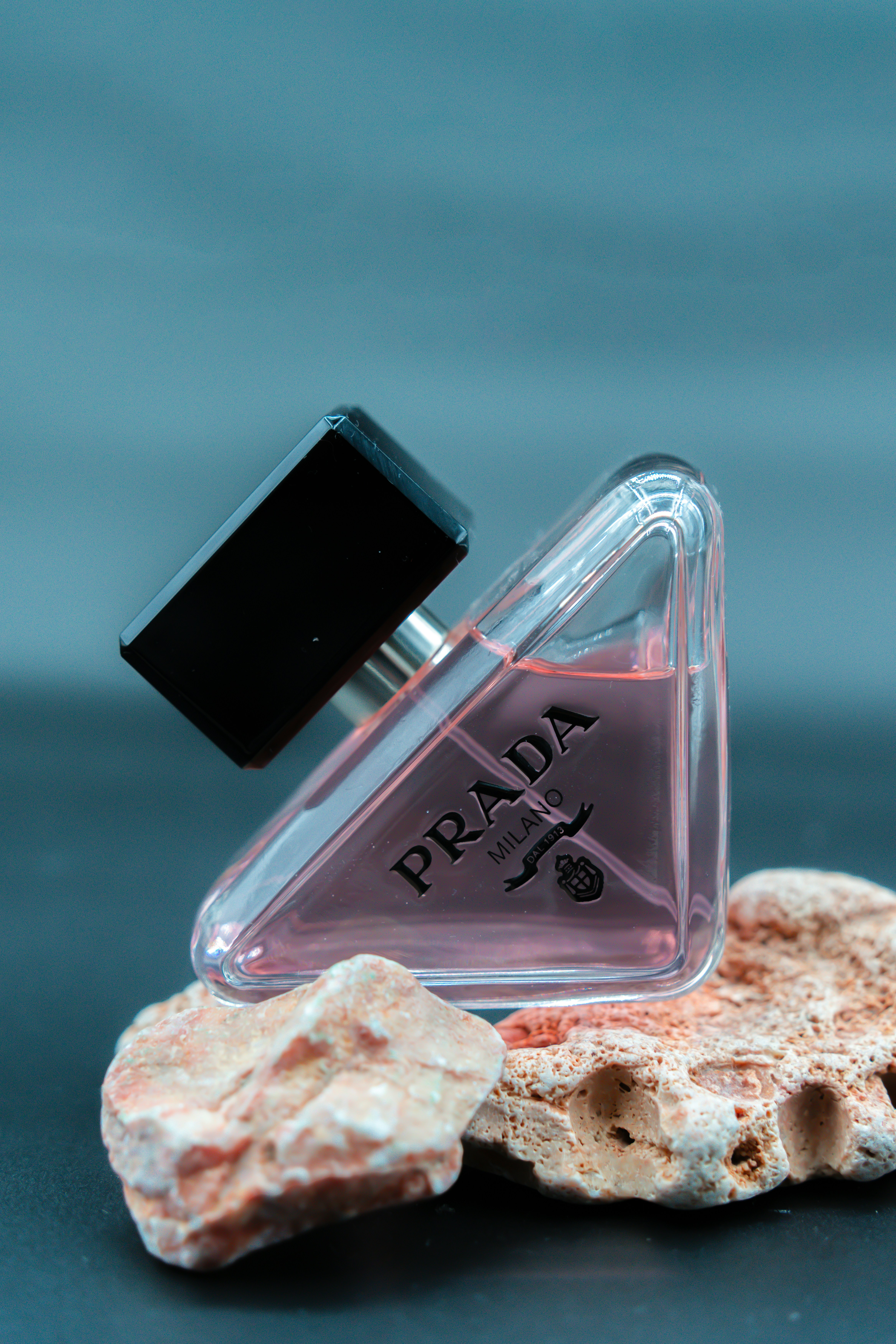 a bottle of perfume sitting on top of a rock