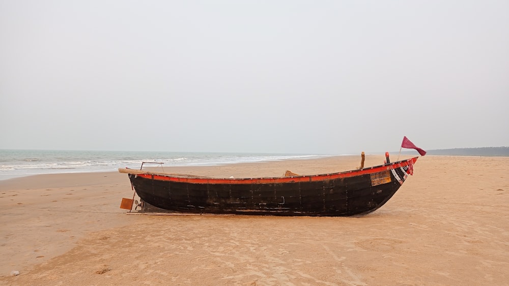 a boat sitting on top of a sandy beach