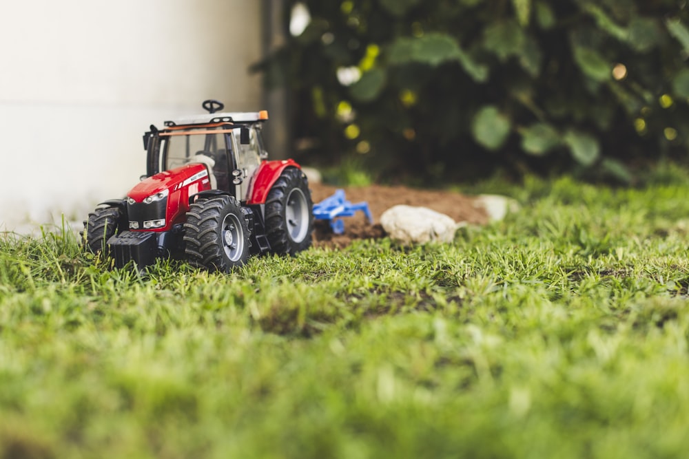 a toy tractor sitting on top of a lush green field
