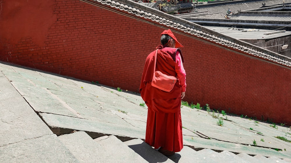 a person in a red robe walking up some steps